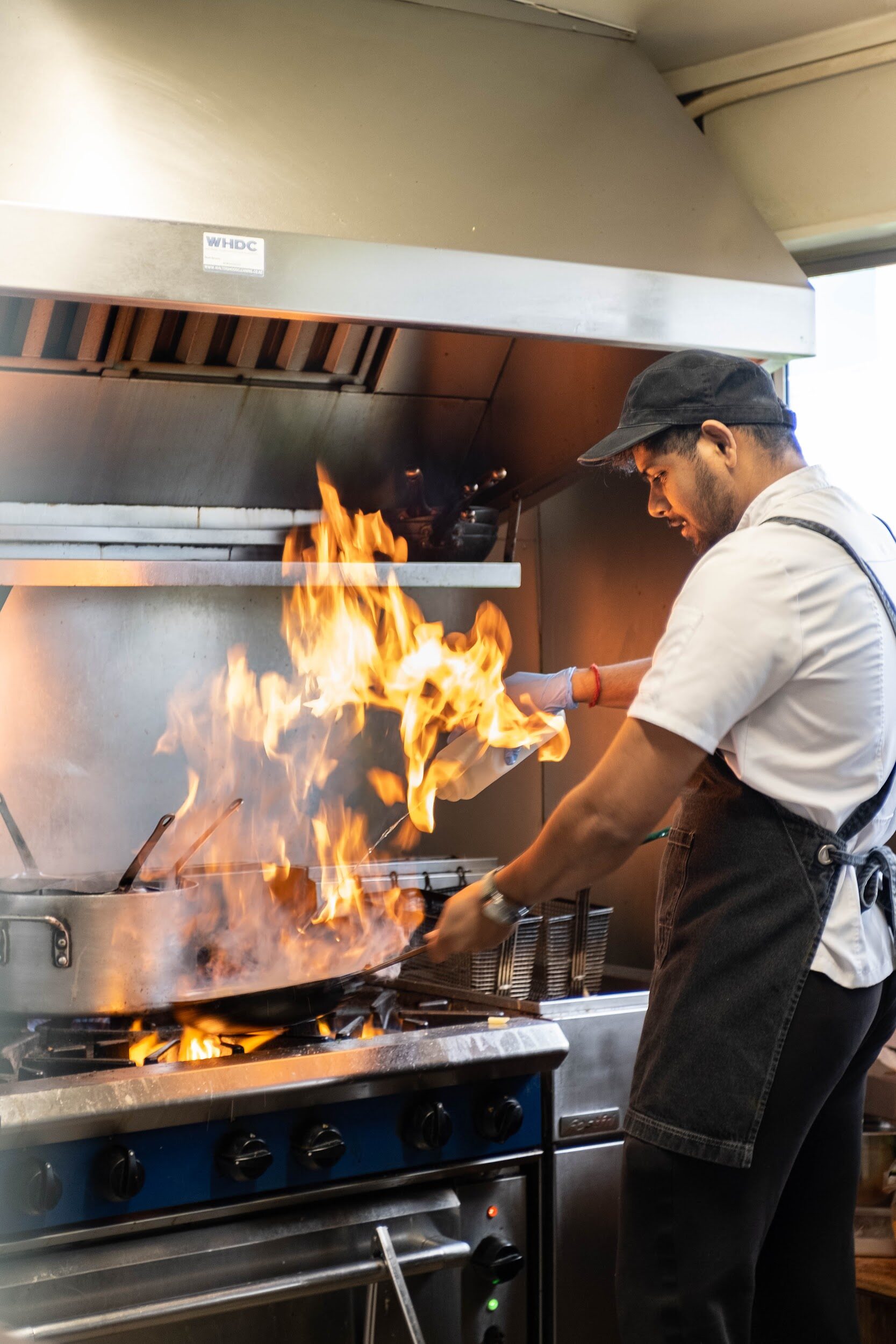 A Bodega Eatery chef cooking over the open flame grill